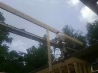 Carpenter setting a ridge beam over a new addition frame — Ice Dam Removal by Roofing Brothers in Cheney
